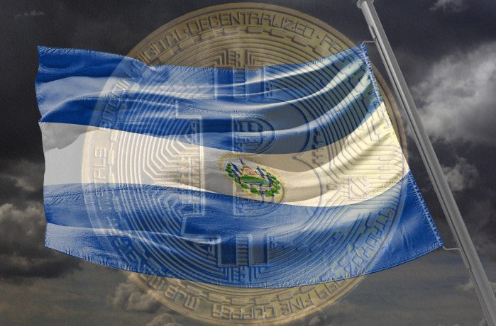 Landesflagge von El Salvador vor einer Bitcoin-Münze.