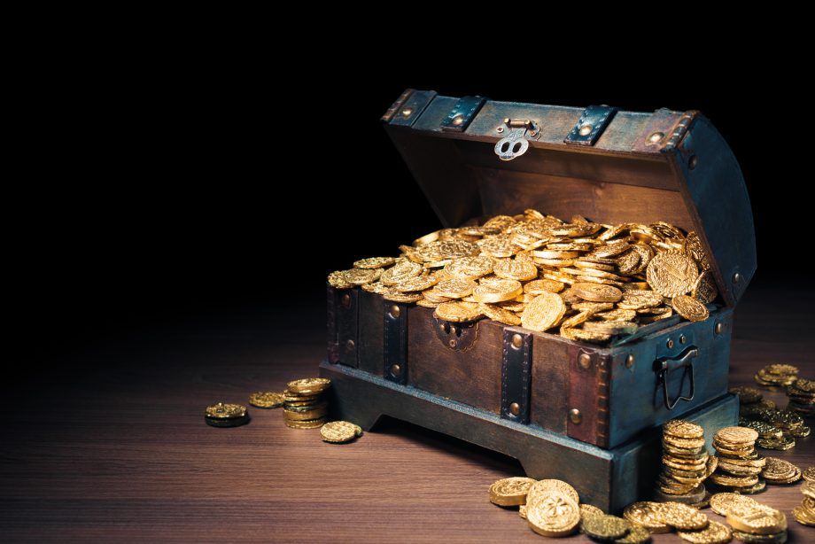 Kriegskasse gut gefüllt – Coinbase sitzt auf 4 Milliarden US-Dollar Truhe gefüllt mit Münzen steht auf Parkettboden