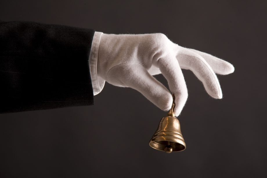 Aktien à la Krypto: DeFiChain eröffnet Stock-Token-Handel Hand schüttelt eine Glocke