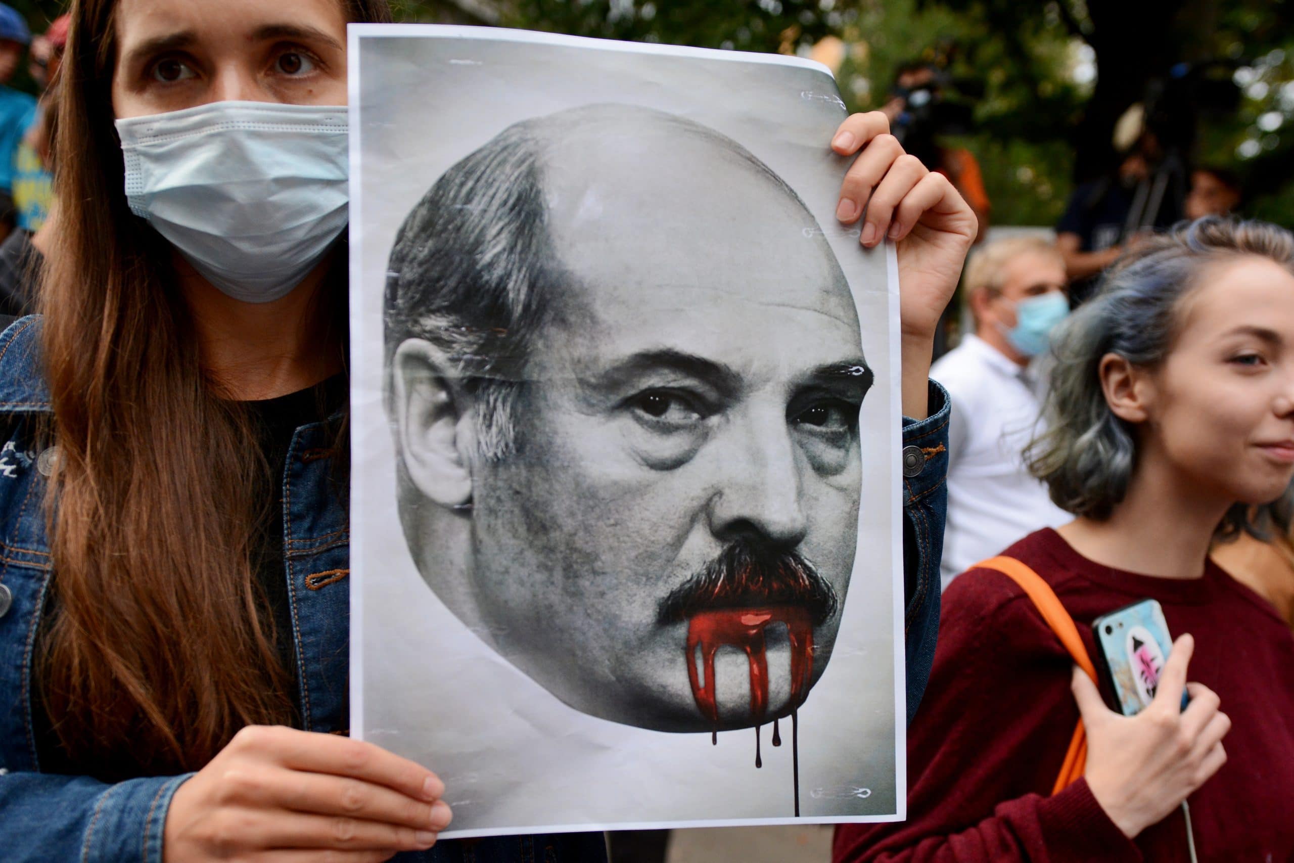 Demonstrantin hält Bild von Lukaschenko hoch