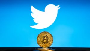 Twitter Logo im Hintergrund, Bitcoin Münze davor