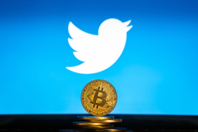 Twitter Logo im Hintergrund, Bitcoin Münze davor