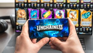 Hände halten ein Telefon mit digitalen Sammelkarten im Hintergrund