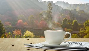 Kaffee und Nachrichten liegen auf Tisch