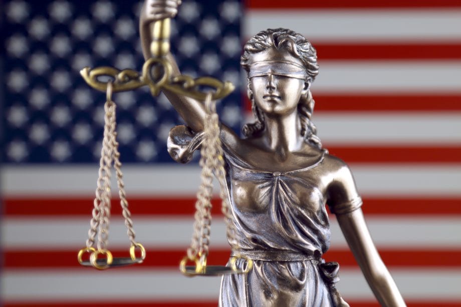 US-Justizministerium stellt Krypto-Team gegen Cybercrime auf Justizia vor der US-amerikanischen Flagge
