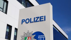 Bild des Polizei Schilds mit NRW Flagge darunter.