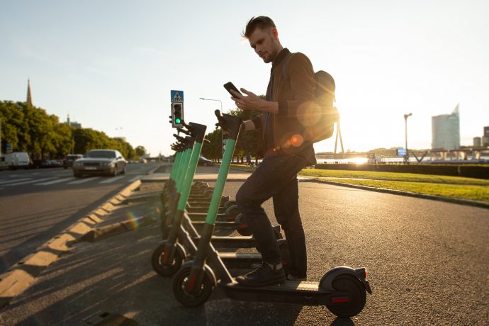 junger Mann mit Roller und Telefon