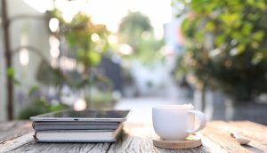 Kaffee, Buch und Tablet auf einem Tisch