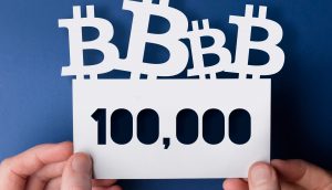 Hände halten ein Bitcoin-Schild hoch