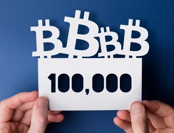 Hände halten ein Bitcoin-Schild hoch