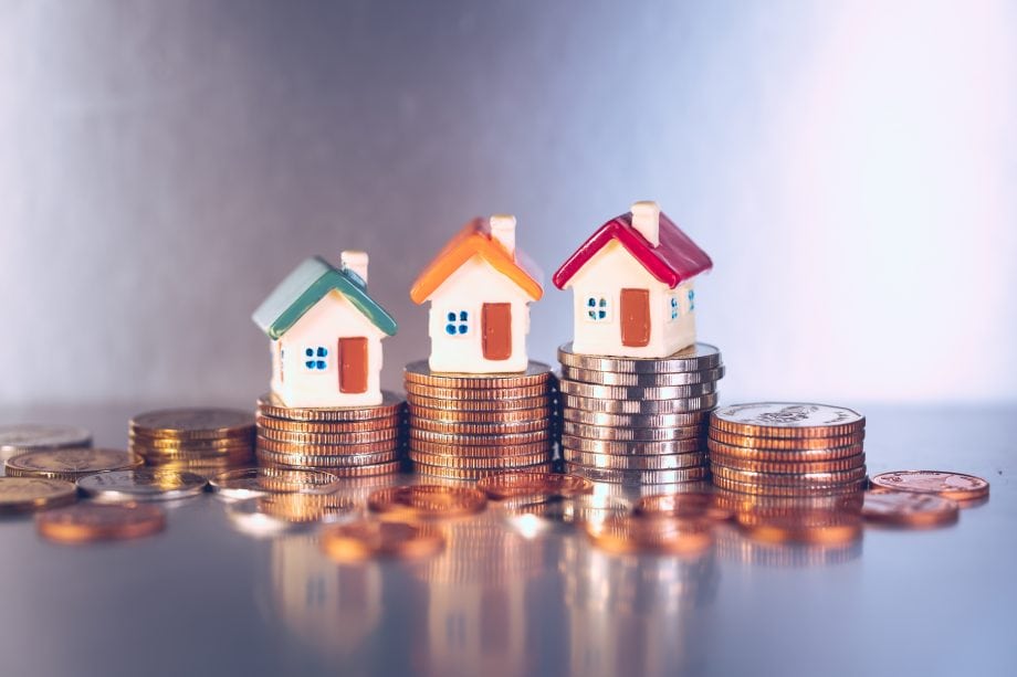 Propy: Immobilienkauf in Minuten mittels Blockchain | BTC-ECHO Kleine Häuschen auf unterschiedlich hohen Geldstapeln aufgetürmt