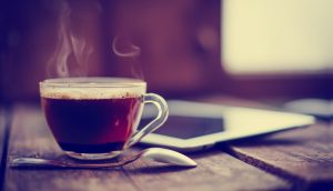 Kaffeetasse neben Tablet