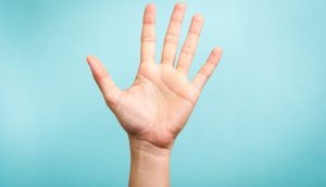 Eine Hand ist zu sehen, die die 5 Krypto-Thesen symbolisiert