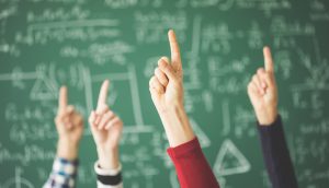 Schüler heben Finger im Klassenraum