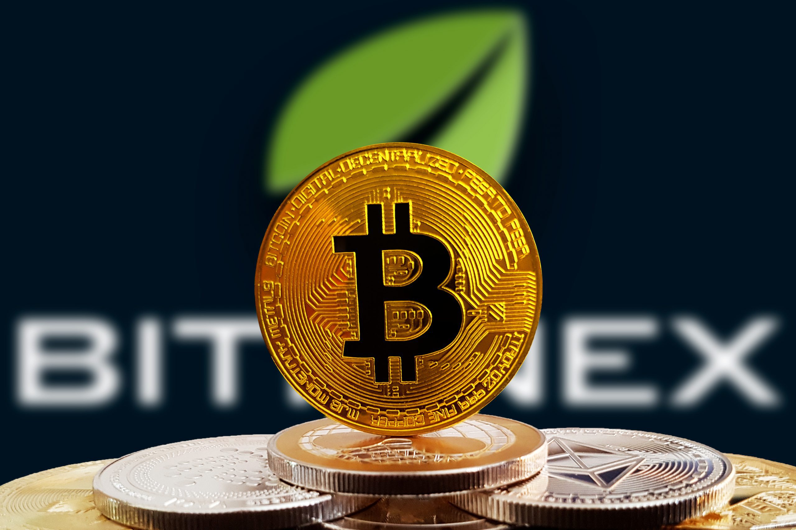 Bitcoin-Münze vor Bitfinex-Logo