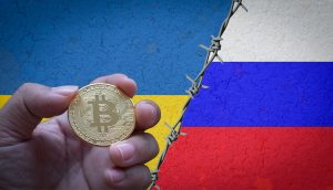 Bitcoin Münze zwischen Ukraine- und Russland-Flagge