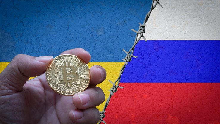 Bitcoin Münze zwischen Ukraine- und Russland-Flagge