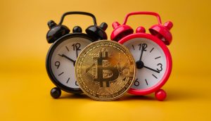 eine bitcoin münze, die vor zwei weckern (schwarz und rot) steht auf gelbem hintergrund