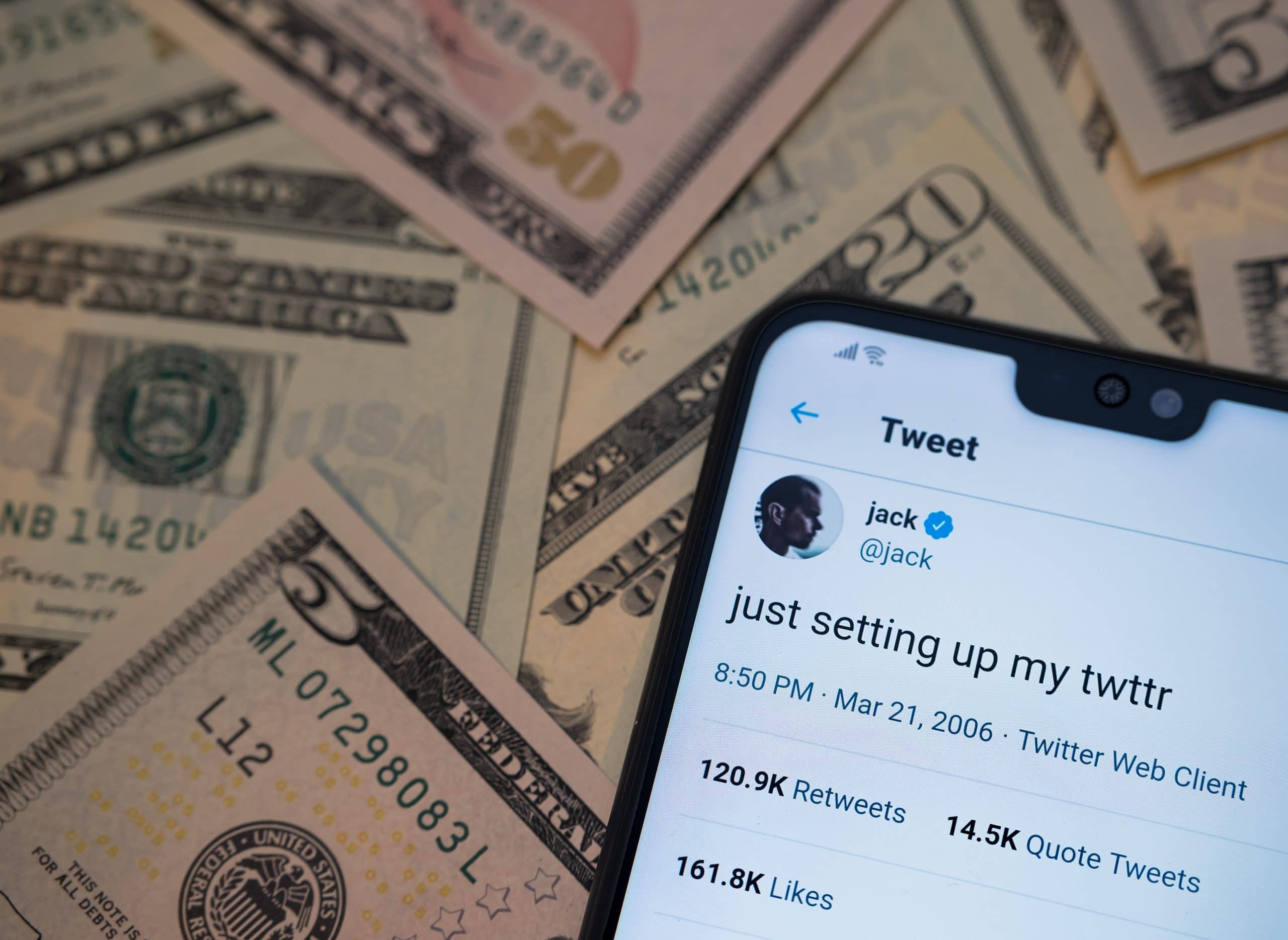 Erster Tweet neben einem Haufen US-Dollar