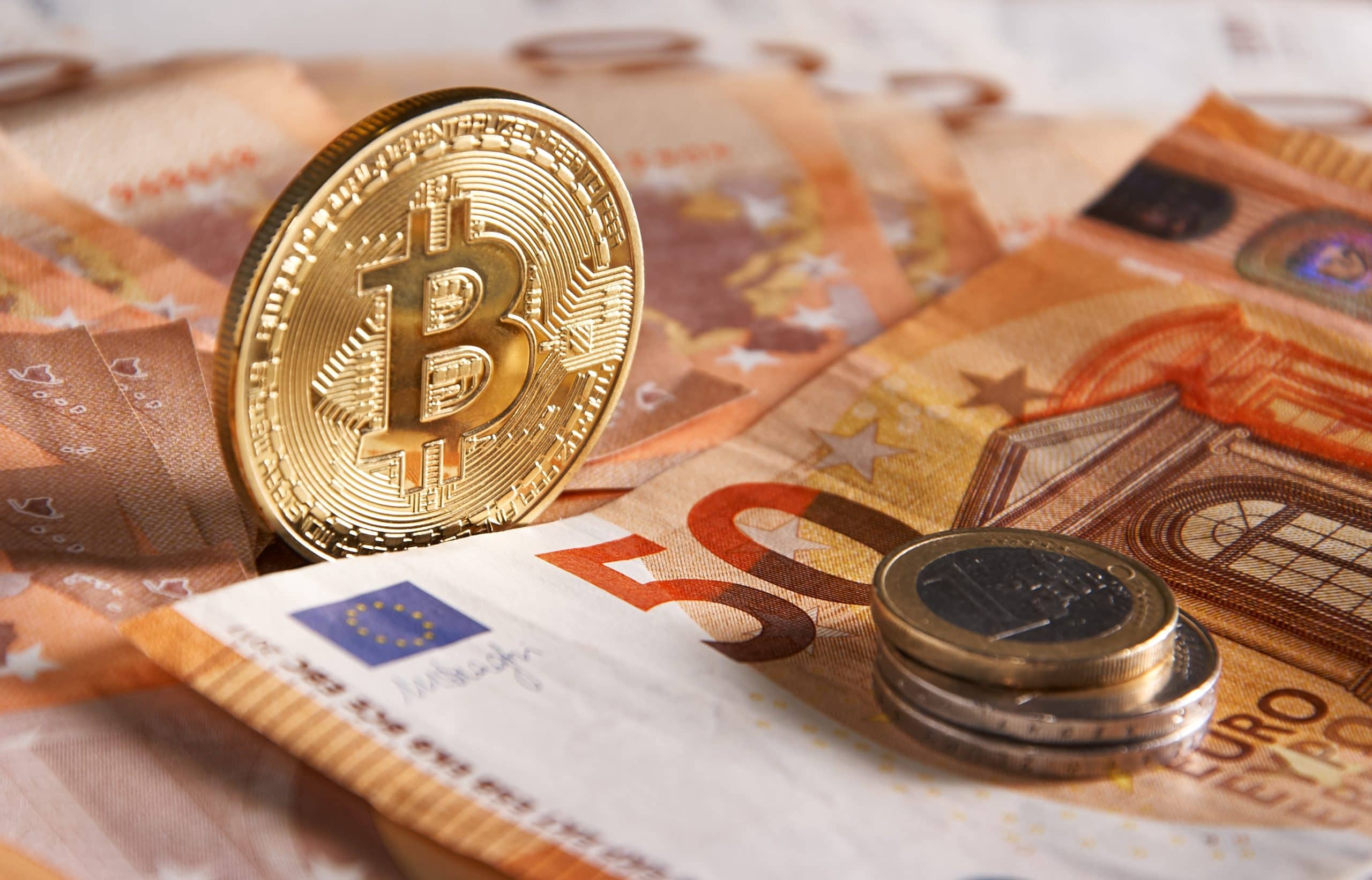 Bitcoin-Münze und 50 Euro Scheine