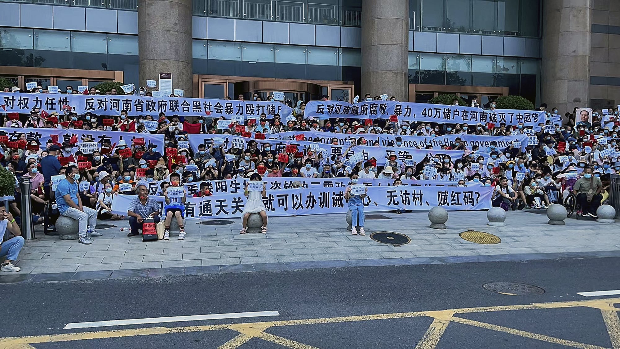 Demonstranten sitzen vor einer Filiale der PBoC in der chinesischen Provinz Henan.