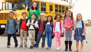 Kinder vor einem gelben amerikanischen Schulbus