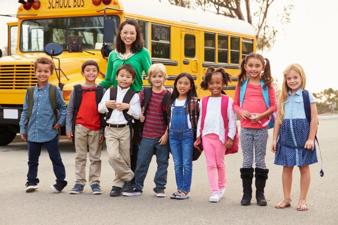 Kinder vor einem gelben amerikanischen Schulbus