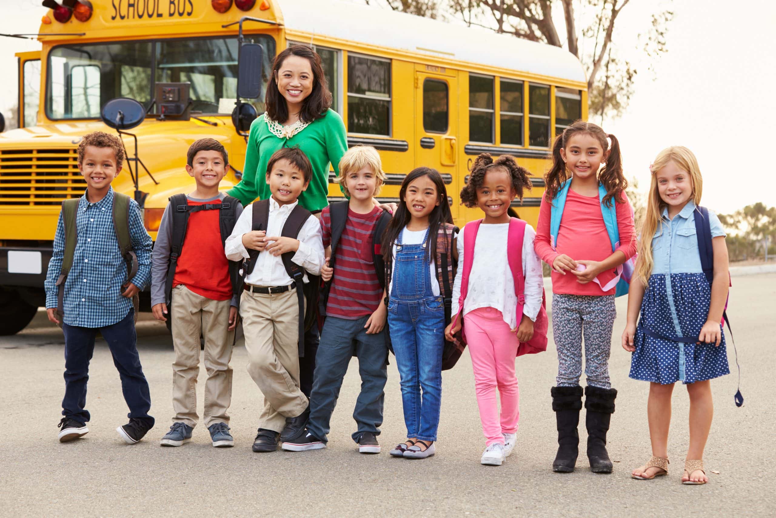 Kinder vor einem gelben amerikanischen Schulbus