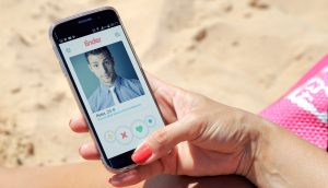 Hand mit einem Smartphone, auf dem die Tinder-App geöffnet ist