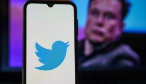 elon musk mit smartphone und twitter symbol