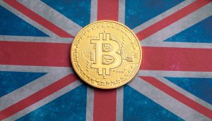 Eine goldene Bitcoin-Münze glänzt auf einer Oberfläche, die mit dem ikonischen Design der Flagge des Vereinigten Königreichs verziert ist und die Verschmelzung von traditionellem Erbe und innovativen Krypto-Trends symbolisiert.