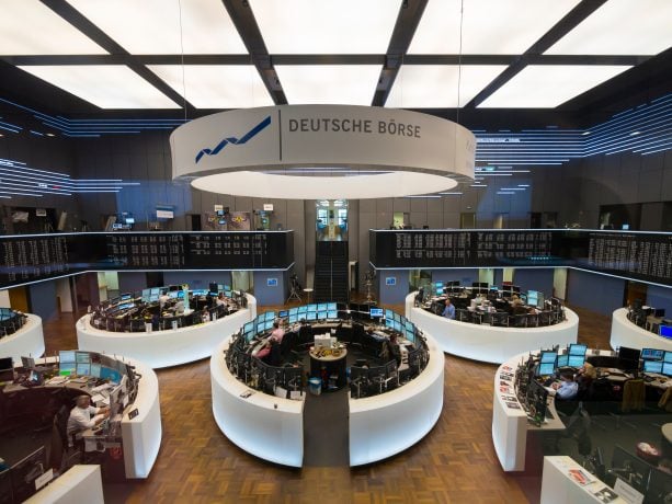 Im Inneren der Frankfurter Börse herrscht reges Treiben. An den runden Handelstischen stehen Computermonitore und geschäftige Händler. Über der Börse prangt stolz ein Schild mit der Aufschrift „Deutsche Börse“, das Herz der europäischen Finanzwelt.