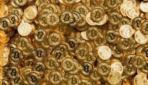 Ein Stapel glänzender goldfarbener Münzen, jede mit dem ikonischen Bitcoin-Symbol verziert, bedeckt das gesamte Bild.