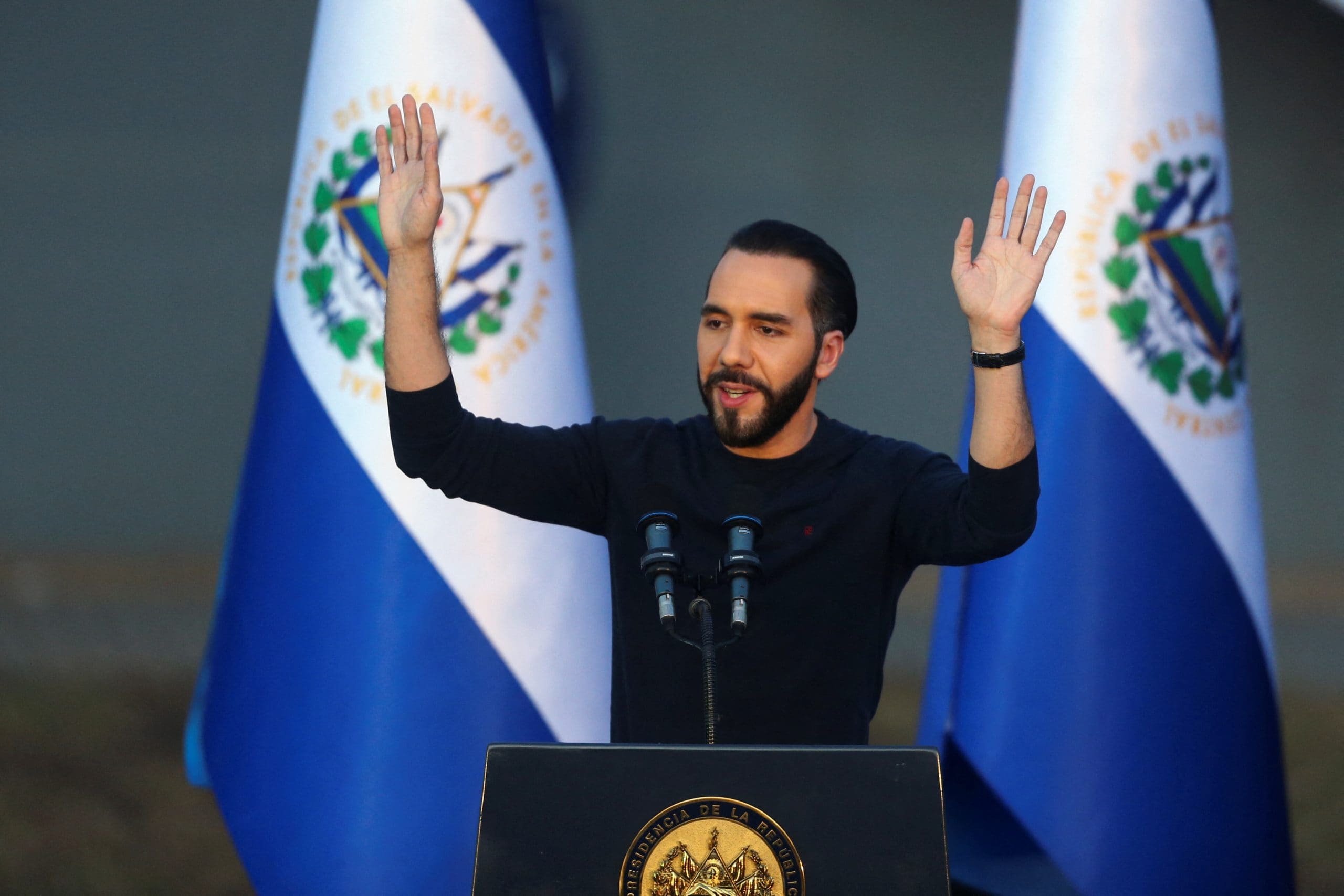 El Salvadors Präsident Nayib Bukele lässt sich feiern vor zwei salvadorianischen Fahnen