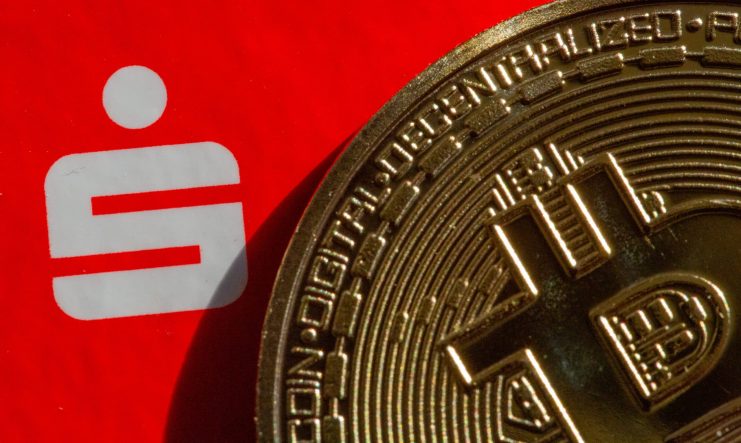 Die Vorteile der Blockchain vor dem Hintergrund der Sparkassen-Störung werden durch eine Bitcoin-Münze vor dem Hintergrund des Sparkassen-Logos symbolisiert