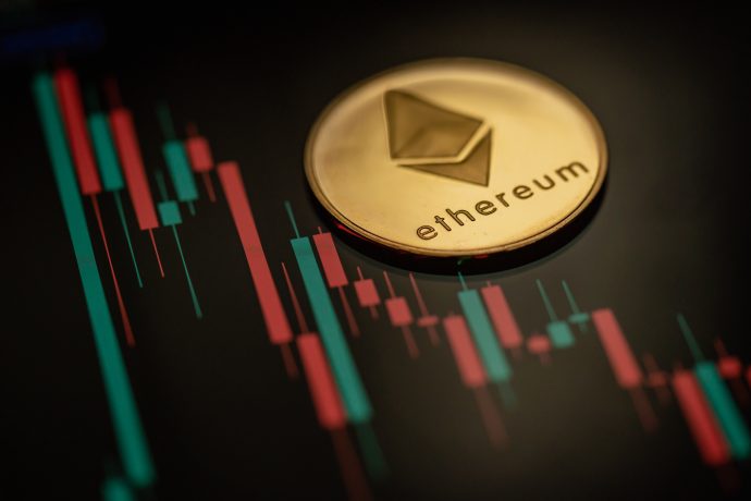 Eine glänzende goldene Ethereum-Münze ruht elegant auf einem digitalen Bildschirm, der ein leuchtendes rot-grünes Kerzendiagramm anzeigt, das dynamische Marktdaten für Kryptowährungen widerspiegelt.