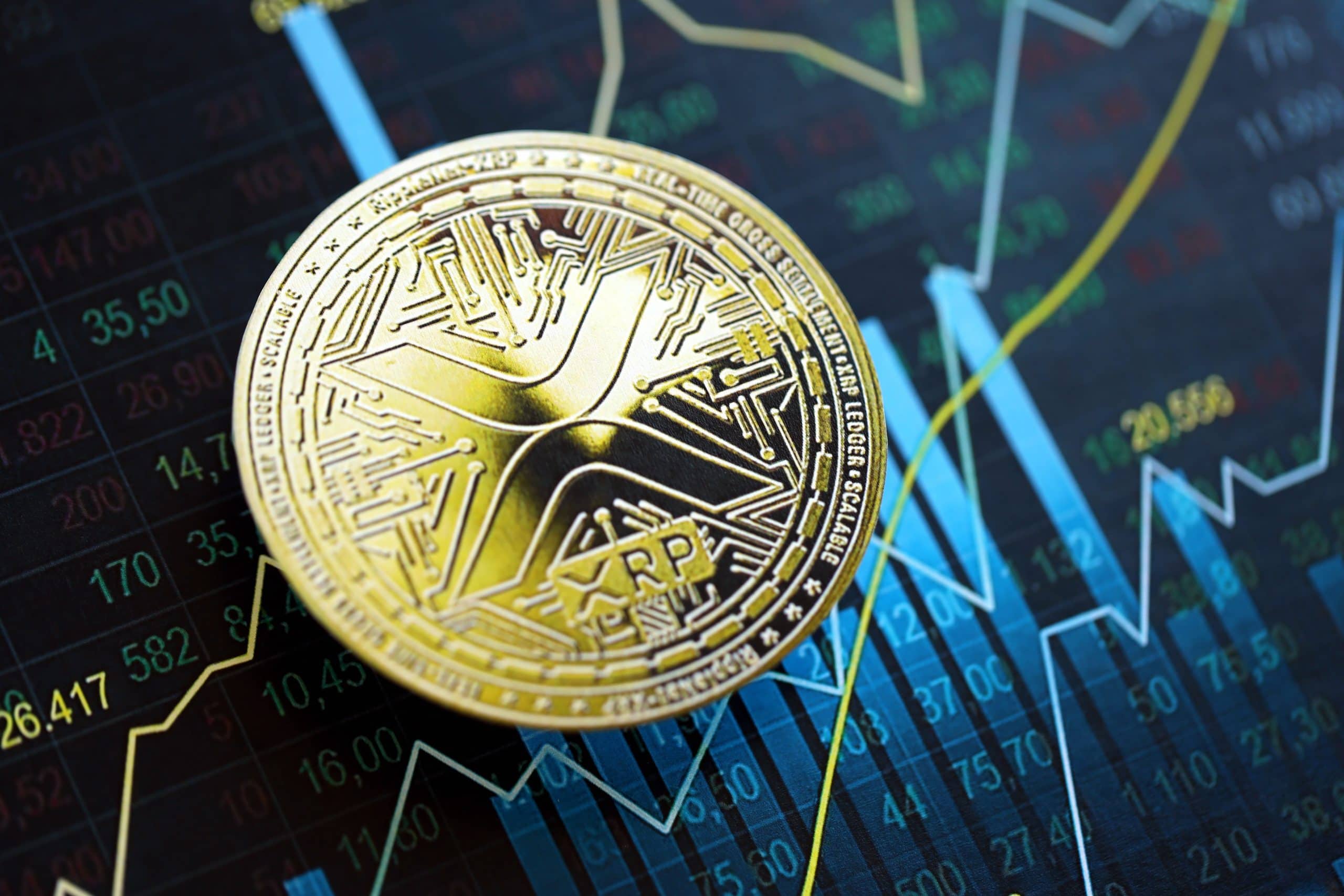 Eine physische XRP-Münze hebt sich vor dem Hintergrund eines digitalen Aktiencharts ab, wobei schwankende blaue und weiße Diagrammlinien die dynamische Marktpräsenz von XRP hervorheben.