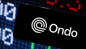 Auf einem Smartphone-Bildschirm ist das Ondo-Logo deutlich zu sehen. Im Hintergrund findet sich ein Börsendiagramm.