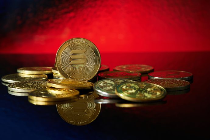 Solana Coins vor rotem Hintergrund