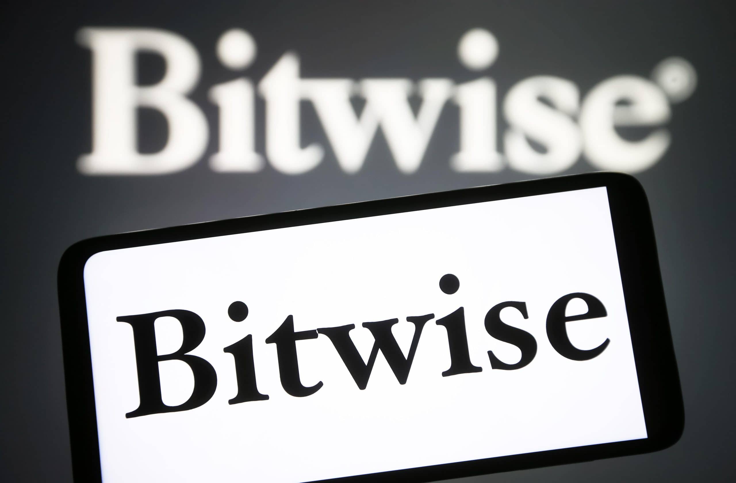 Auf einem Smartphone wird das Logo von „Bitwise“ plastisch dargestellt, im Hintergrund ist eine unscharfe Projektion des Krypto-Indexfonds des Vermögensverwalters zu sehen.
