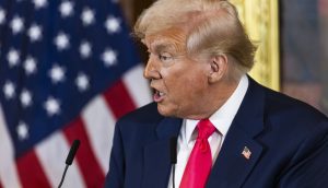 US Supreme Court kippt Trump-Zölle Bitcoin: Donald Trump spricht vor US-Flagge am Rednerpult