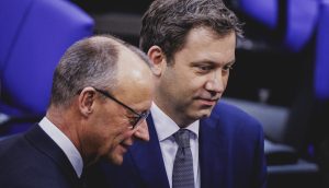 Friedrich Merz (links) und Lars Klingbeil (rechts) unterhalten sich im Bundestag.