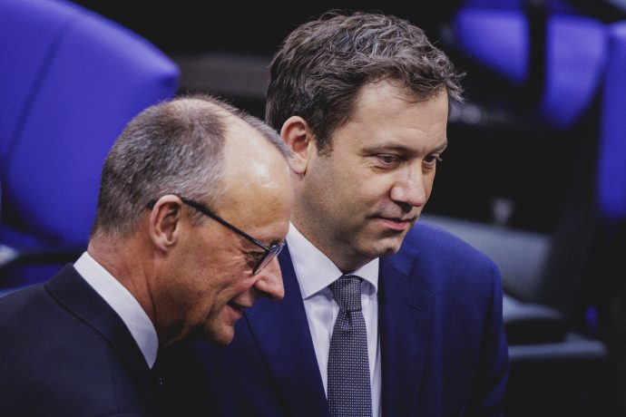 Friedrich Merz (links) und Lars Klingbeil (rechts) unterhalten sich im Bundestag.