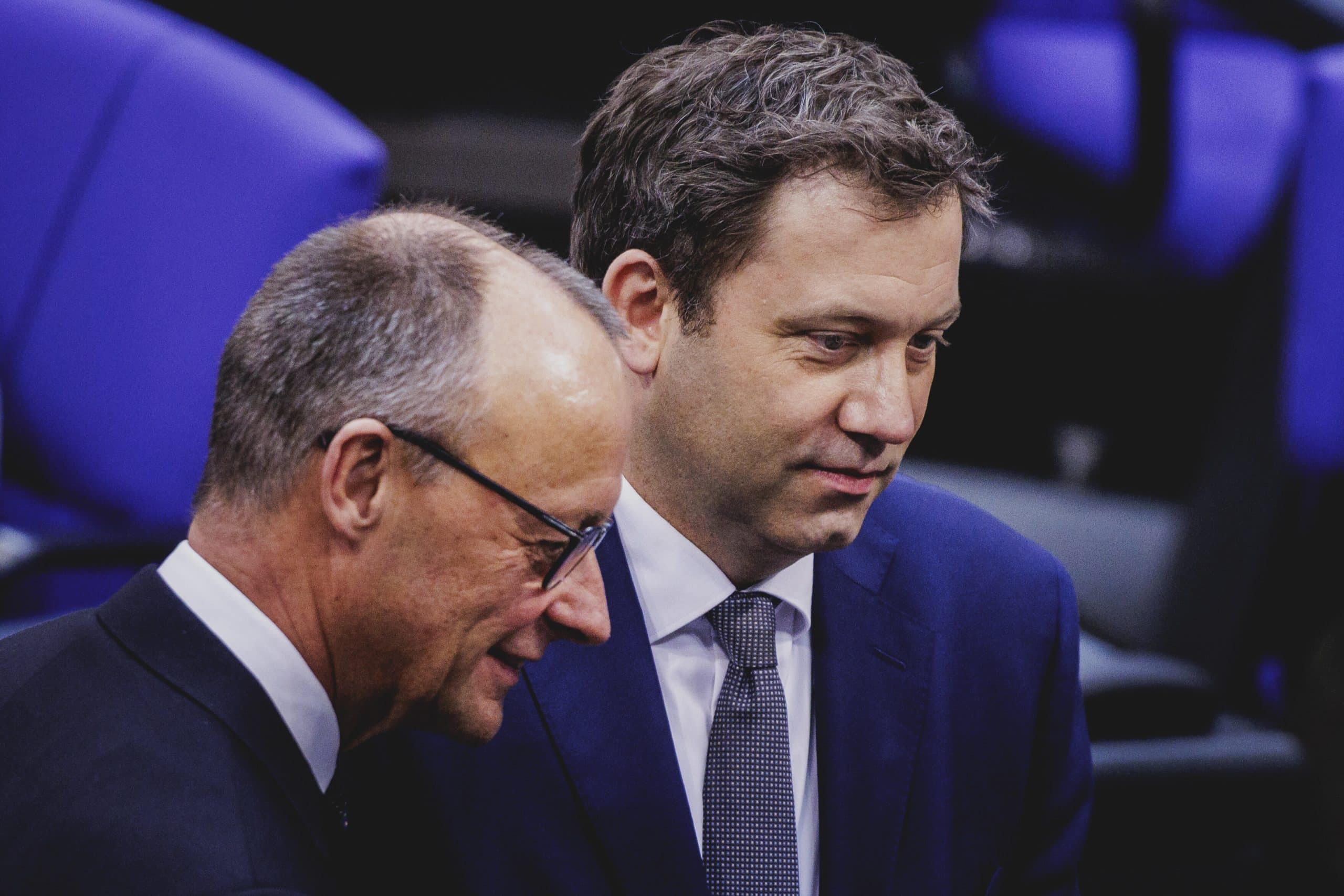 Friedrich Merz (links) und Lars Klingbeil (rechts) unterhalten sich im Bundestag.
