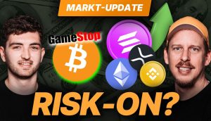 Zwei Männer stehen vor Kryptowährungs- und Aktiensymbolen, neben den Texten „RISK-ON?“ und „MARKT-UPDATE“ und fangen den Puls des Krypto-Marktes ein. Zeichnet sich ein Aufwärtstrend ab? Bleiben Sie dran mit BTC-ECHO für aufschlussreiche Updates.