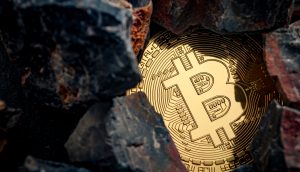 Eine goldfarbene Bitcoin-Münze ist teilweise von dunklen Felsen umgeben, was den Reiz von Bitcoin inmitten des zerklüfteten Geländes unterstreicht.