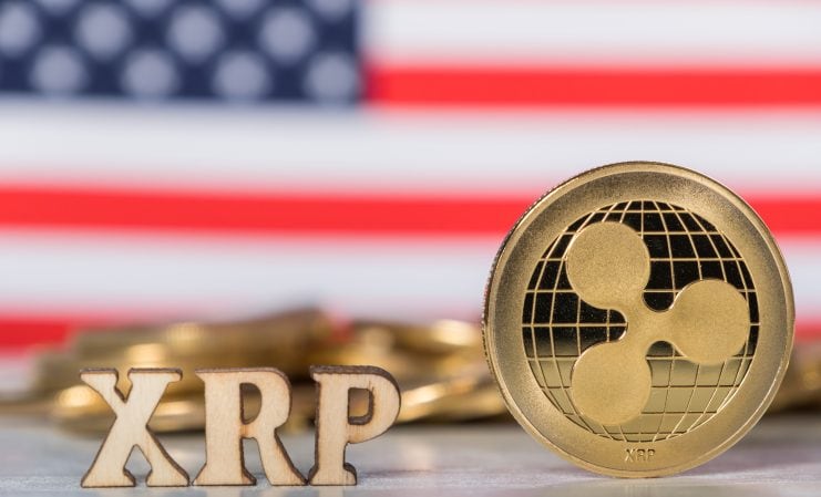 XRP-Schriftzug und Ripple-Coin vor einer US-Flagge