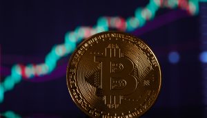 Im Vordergrund glänzt eine goldene Bitcoin-Münze vor einem unscharfen Hintergrund, der ein steigendes Finanzdiagramm hervorhebt und optimistische Diskussionen über die Bitcoin-Prognose für 2025 widerspiegelt.