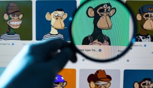 Eine Person hält eine Lupe über einen Computerbildschirm, auf dem eine Sammlung illustrierter Affenfiguren angezeigt wird, als würde sie einen automatisch gespeicherten Entwurf auf versteckte Details untersuchen.