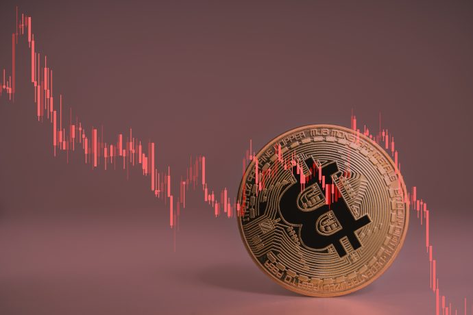 Eine Bitcoin-Münze vor rotem Hintergrund